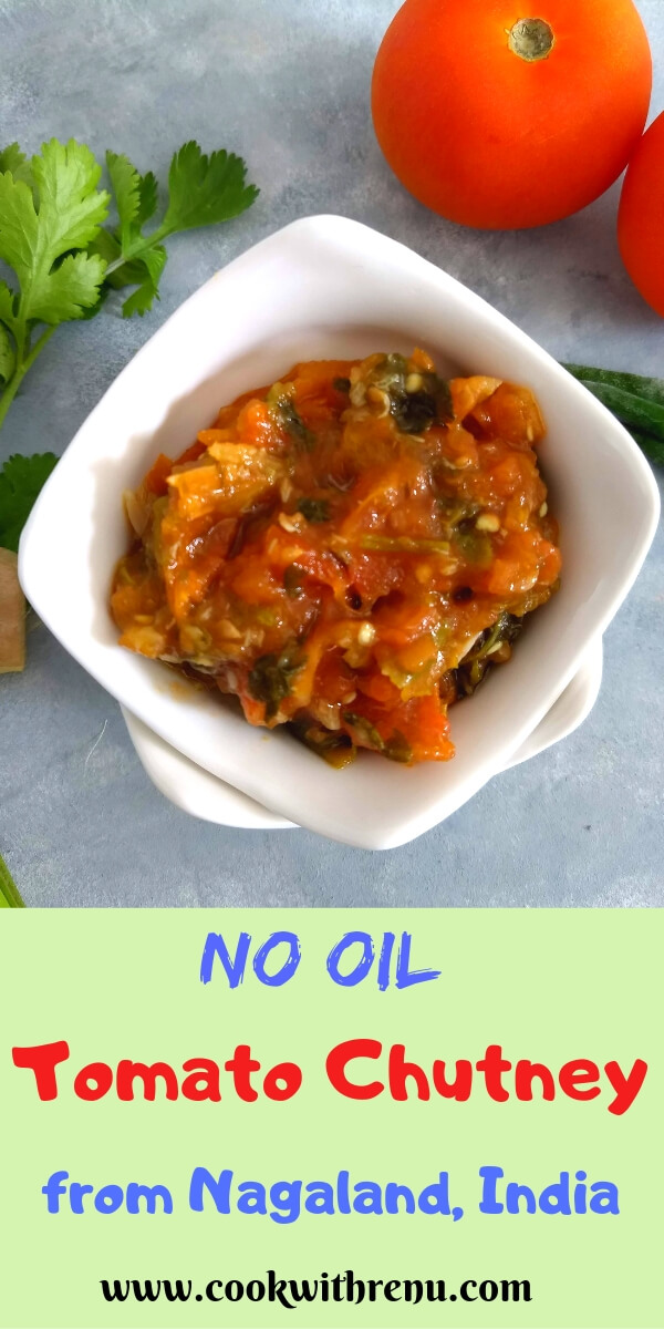 No Oil Tomato Chutney from Nagaland served in a white bowl. Seen in the background are some tomatoes, green chili, and coriander.