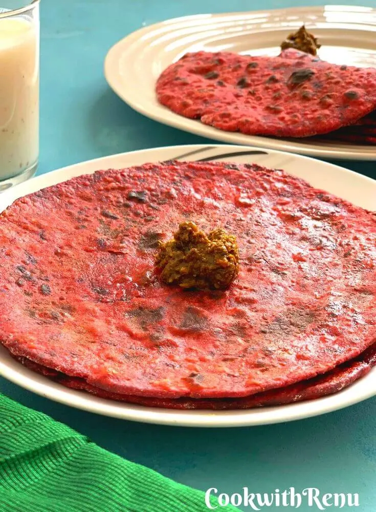 Closer look of the Red and Bright Beetroot Paratha, served with a dollop of a, chaar , dry vegetable and Buttermilk