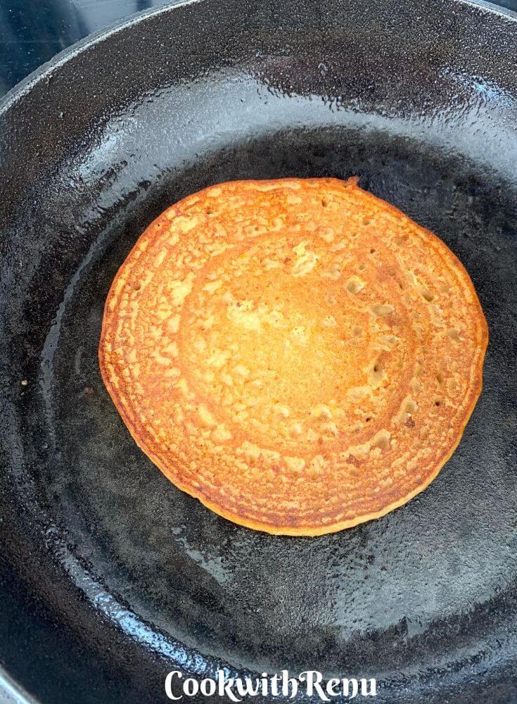 The bottom side of pancake being cooked, and the earlier side which was down is cooked