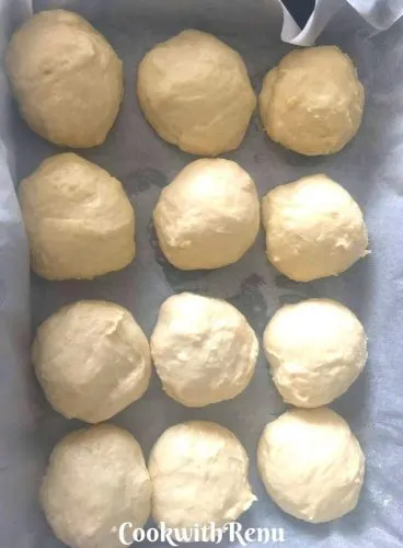 The pav buns being arranged in an oven plate