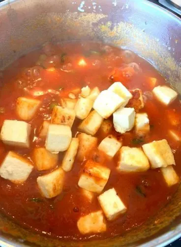 Shallow fried Paneer Cubes being added to gravy