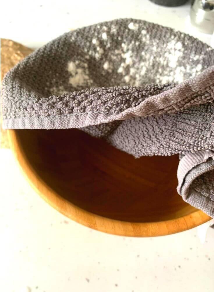 The bowl being getting prepared for Boule, with a napkin dusted with rice flour sitting on a bowl