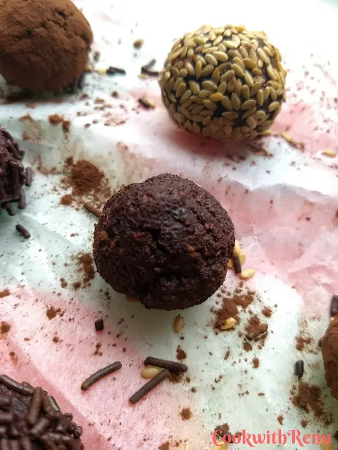 Close up look of the rolled energy bite without any coating. Seen in the background is energy bite coated with sesame seed and cocoa powder