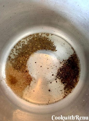 Asafoetida, Cumin seeds, Cloves powder being tempered in oil