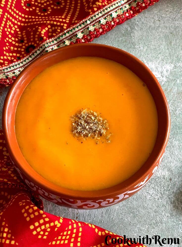 Close up look of Aamras in a bowl, with cardamom powder sprinkled on top