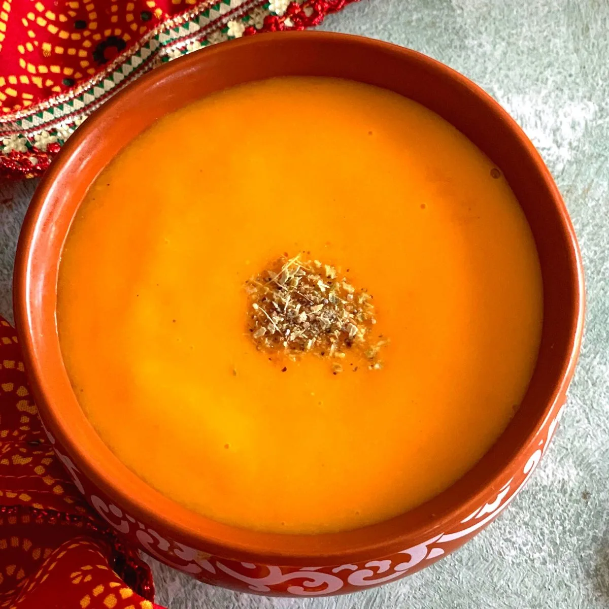 Close up look of Aamras in a bowl, with cardamom powder sprinkled on top