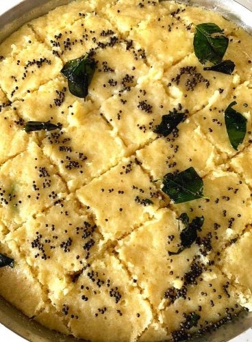 Tempering poured onto the cut slices of the dhokla pieces