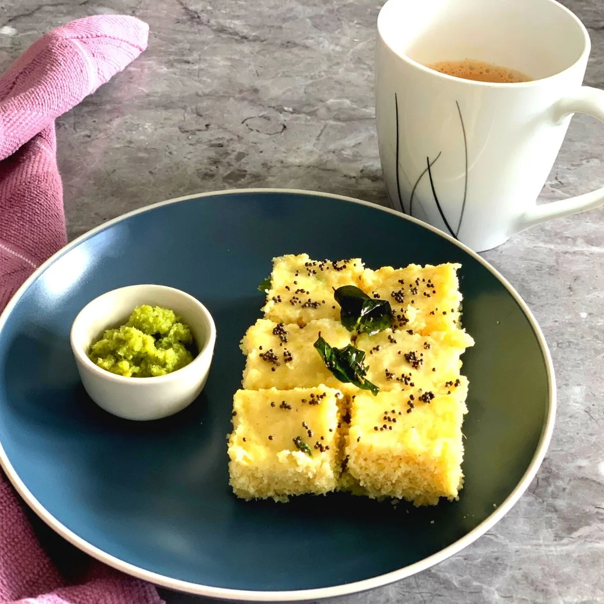 Rava Dhokla being served with Green Coriander Chutney and a cup of tea