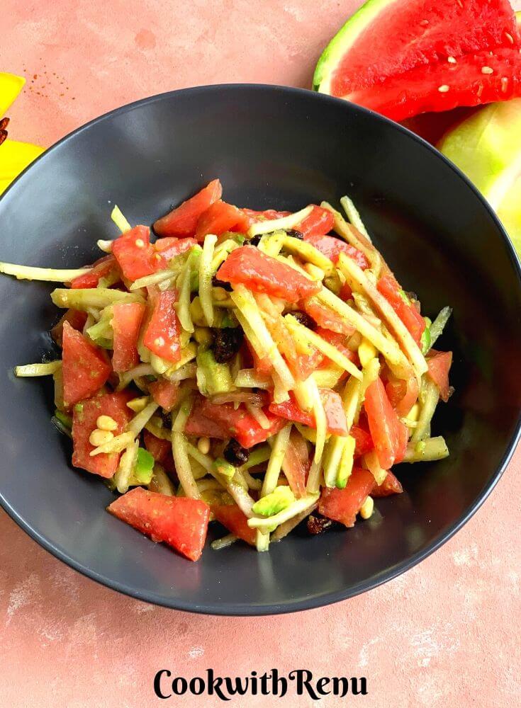 Watermelon and Avocado Salad seen in the pic in a black bowl along with Few pieces of watermelon slices are seen in the background