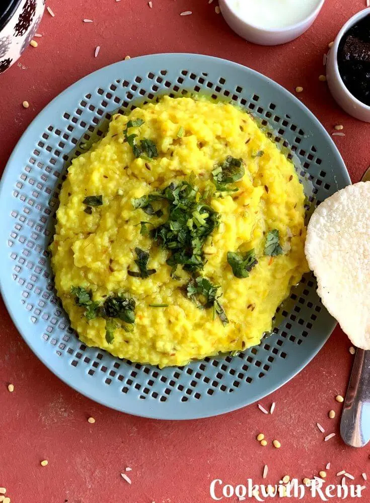 Close up look of Khichdi served with yogurt, homemade lemon pickle and rice papad