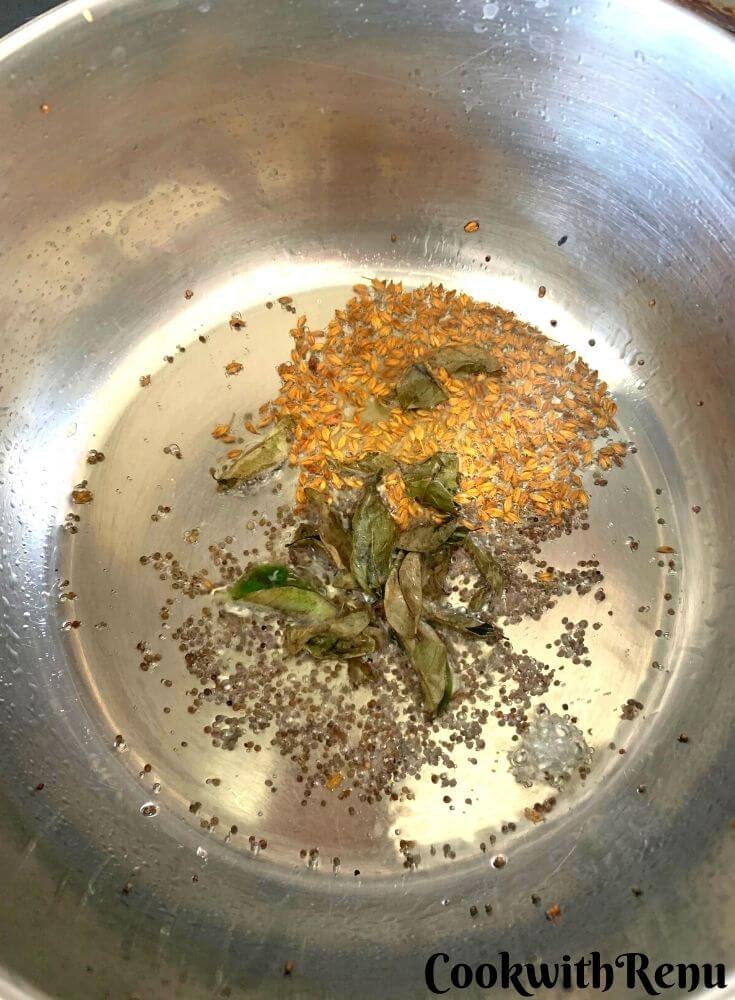 Adding of cumin and curry leaves in the tempering