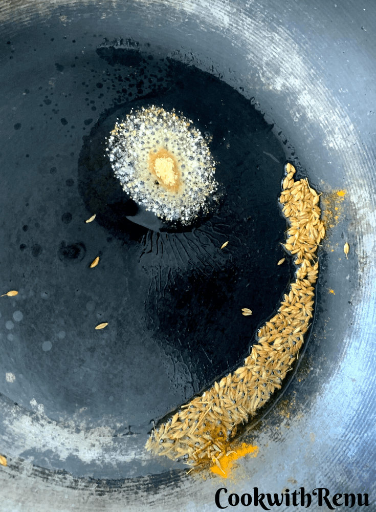 Oil, asafoteida and cumin seeds added in pan