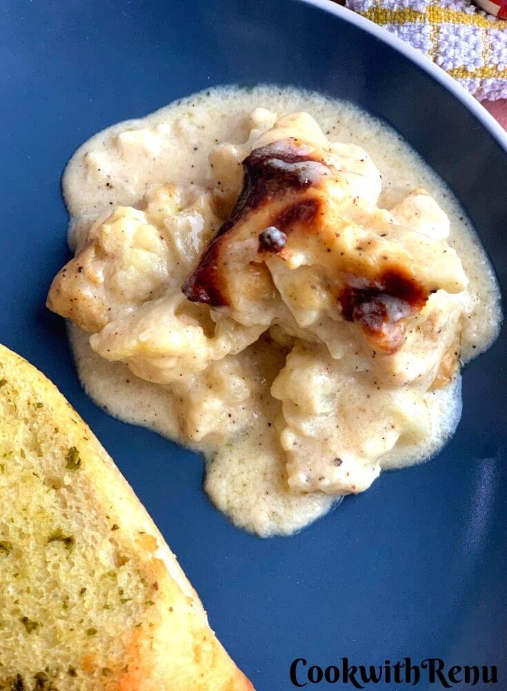 A portion of Cauliflower Gratin served along with garlic bread