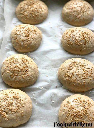The buns sprinkled with sesame seeds and ready to be baked