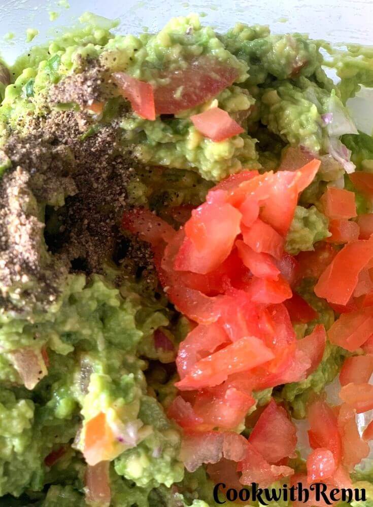 Adding of Tomato, onion, salt, pepper and lemon juice to Avocado