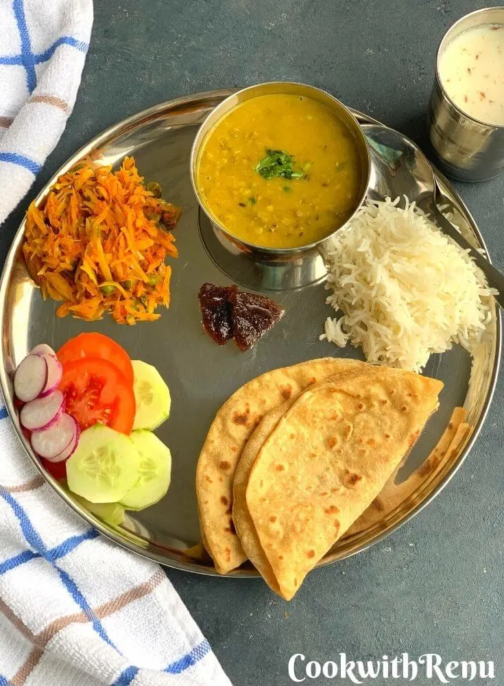 A North Indian Vegetarian lunch thali is a No onion No garlic, simple everyday balanced meal of proteins and carbs from nutritious dal, vegetable, salad, roti and rice.