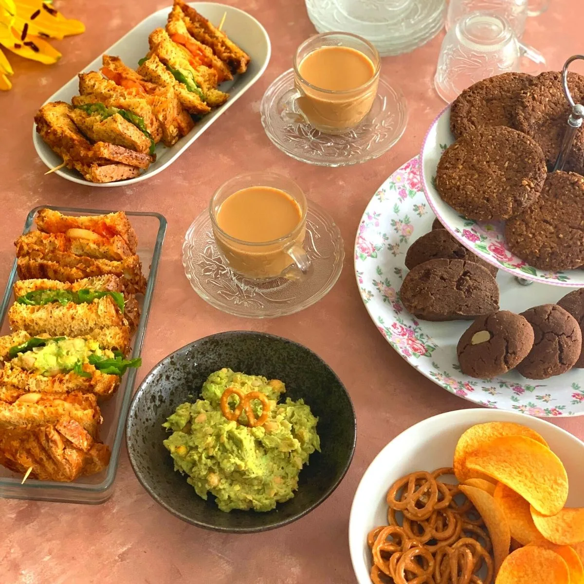 Afternoon Tea Time Platter featuring different types of Vegan Sandwiches, Gluten-Free and nut-free cookies, chips, and dips catering to people with different food groups.