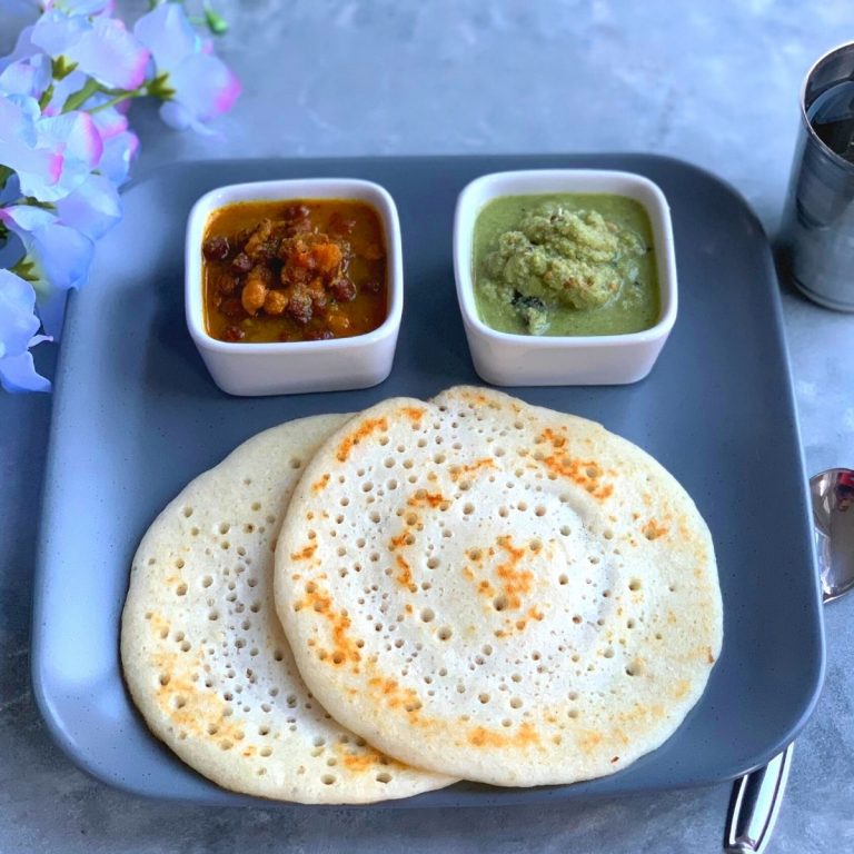 Amboli presented in a square dish with chutney and black chana usal, along with water