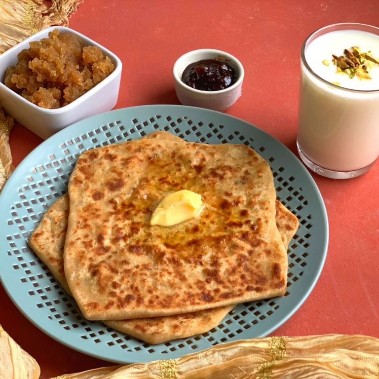 Easy Daikon Paratha served with a dollop of butter, no oil lemon pickle, Sweet Lassi (Yogurt drink) and Ate ka halwa/karah Prasad