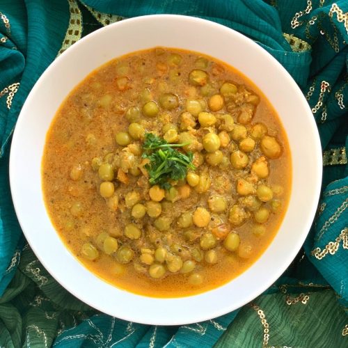 Goan Green Peas Curry served in a white bowl and garnished with coriander. A green stole is seen in the background