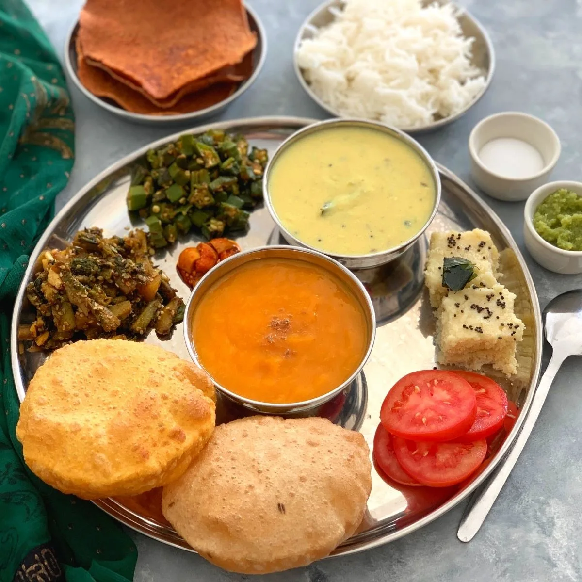 Gujarati Thali is a spectacular treat and fusion of sweet, salty, and spicy flavors all combined in a classic Indian Regional thali.