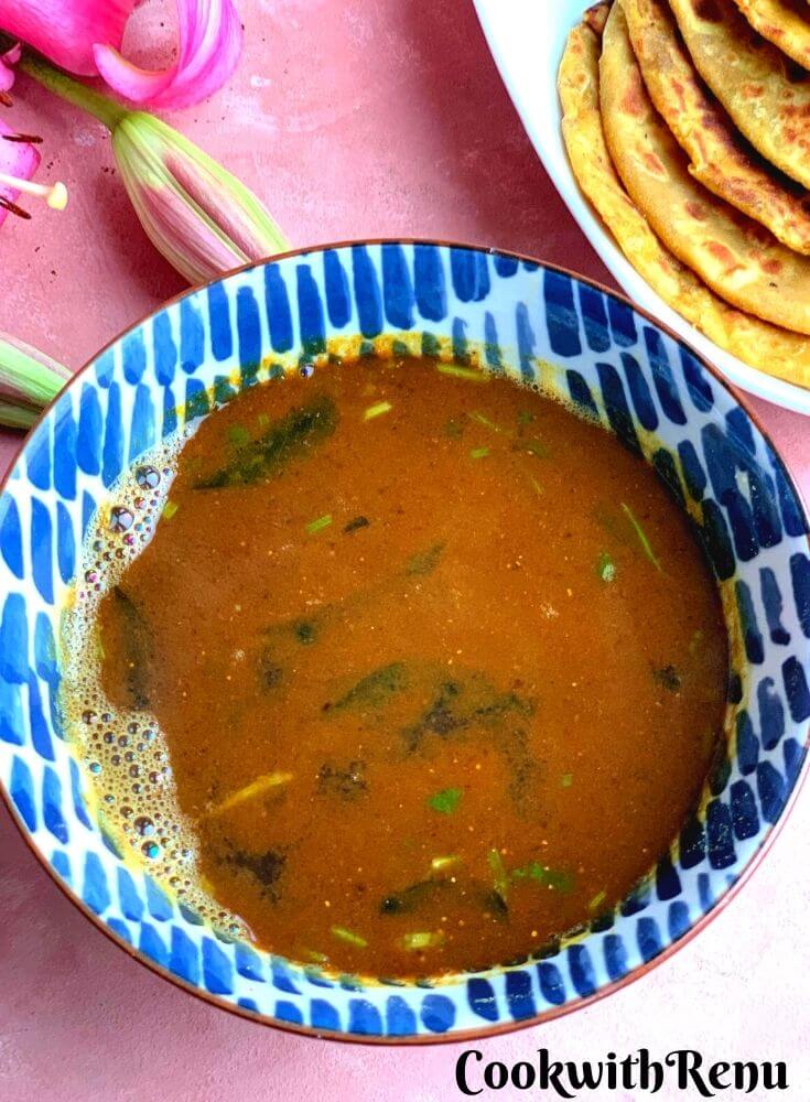 Katachi Amti is a traditional Maharashtrian style thin, spicy, tangy and slightly sweet dal or curry made using the stock of Chana Dal. Served in a blue bowl along with Puran poli