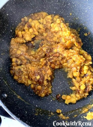 Jaggery and Chana dal mixture getting cooked in a pan