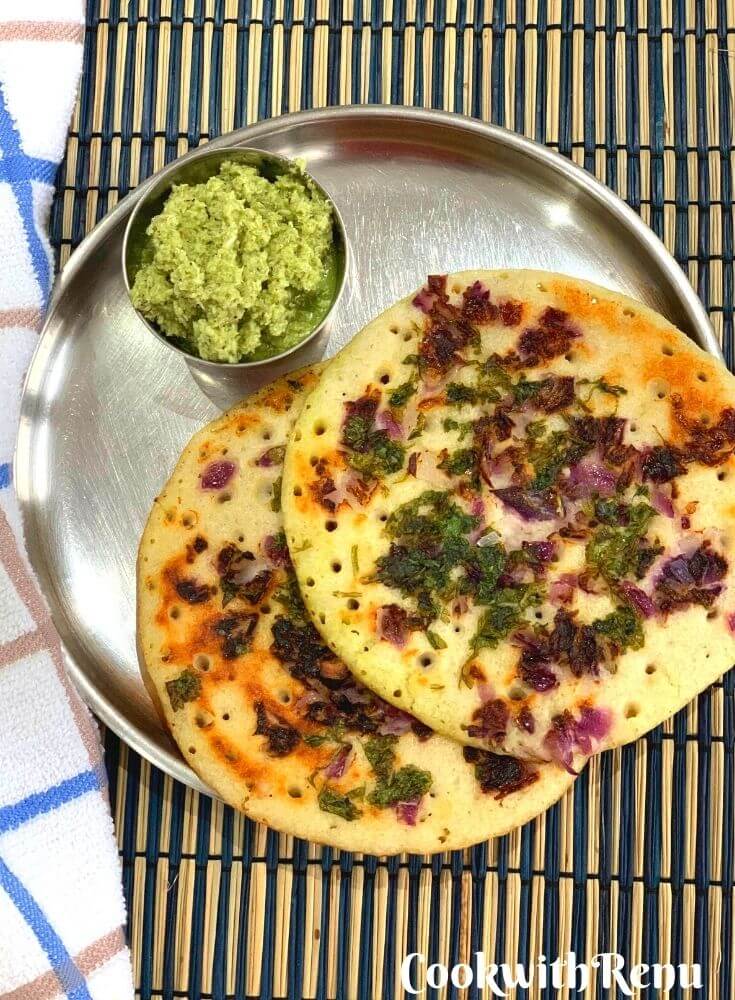 Two Uttapam served in a plate along with coconut coriander chutney
