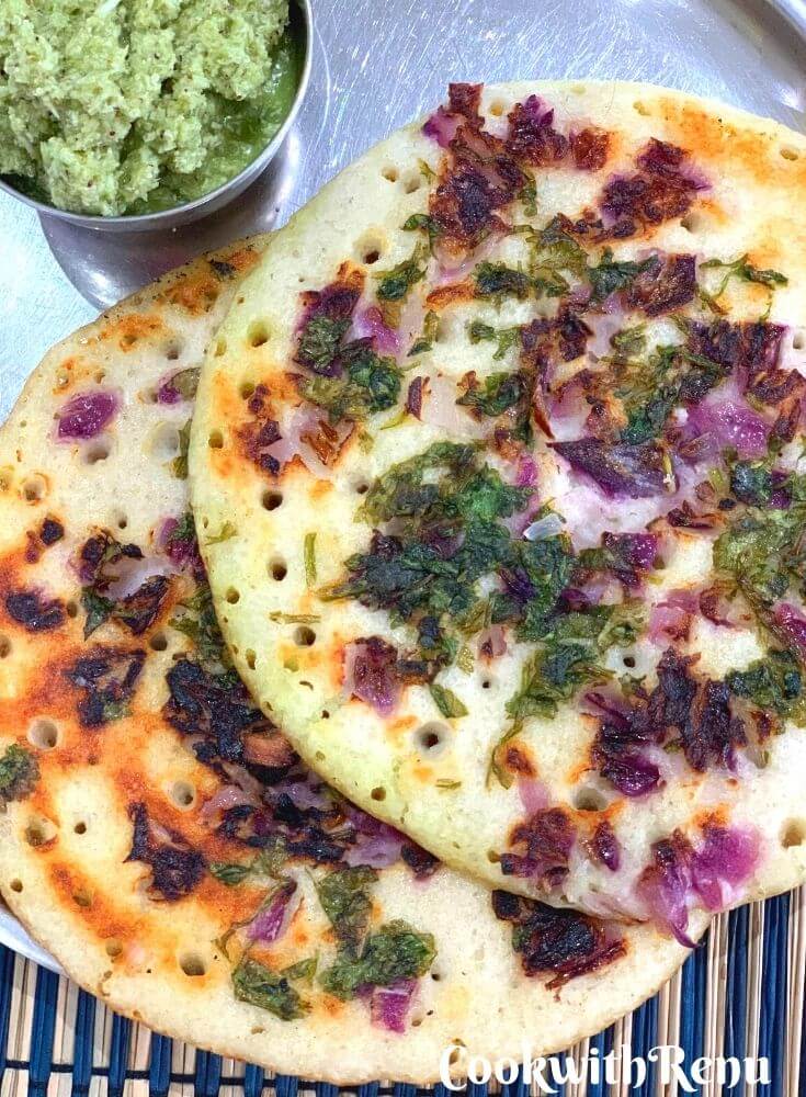 Close up look of Two Uttapam served in a plate along with coconut coriander chutney