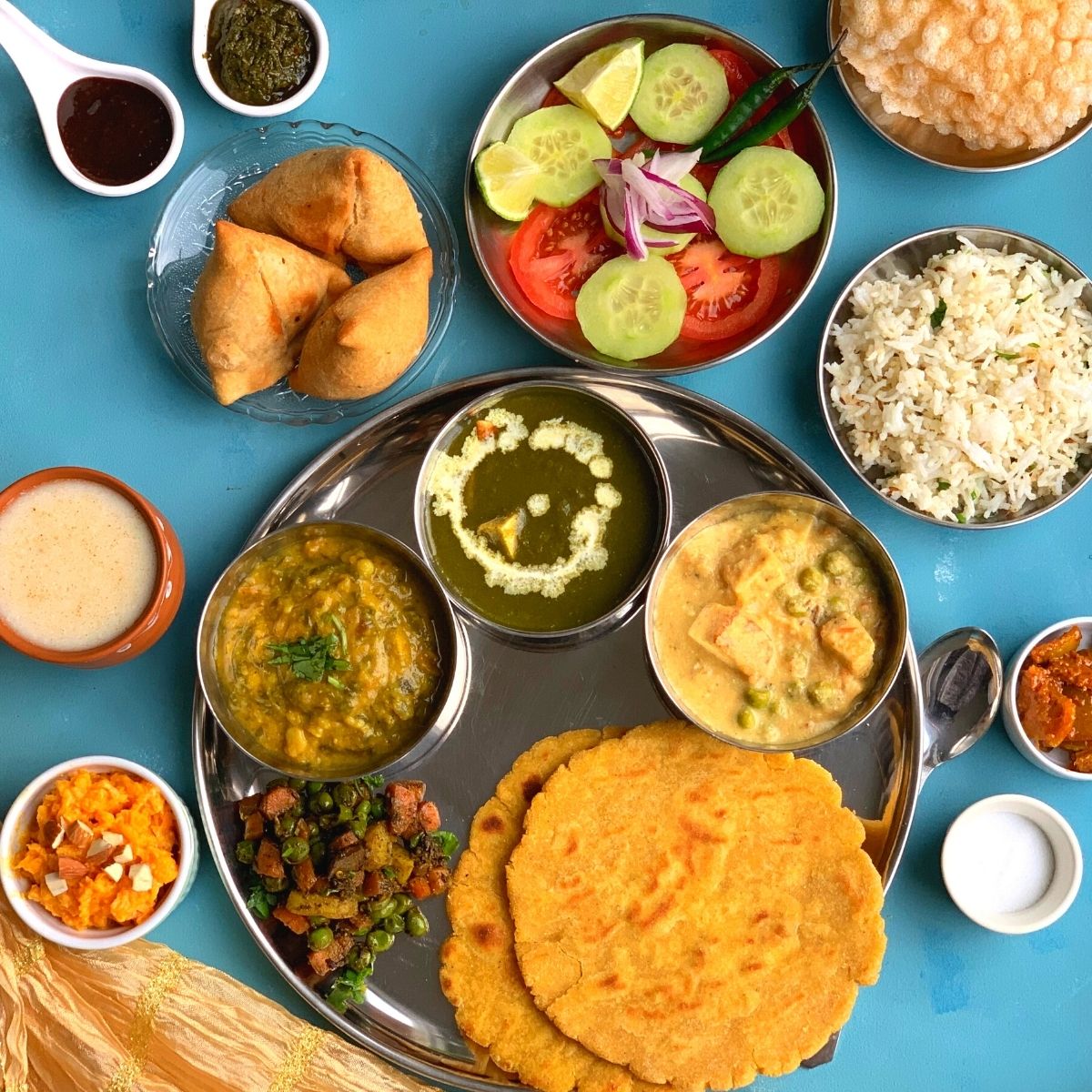 Vegetarian Punjabi thali has a range of rich buttery and paneer based dishes with gluten free makki di roti and Jeera rice.