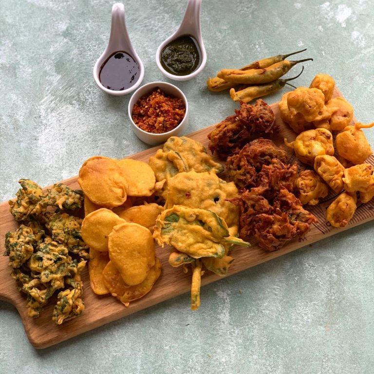 Tea time Pakora Platter is an addictive platter which has 6 different types of pakoras. They are yummy and crunchy snack or tea time fritters. Fritters are served on a wooden board with Coriander, Imli and Garlic chutneys on the side.
