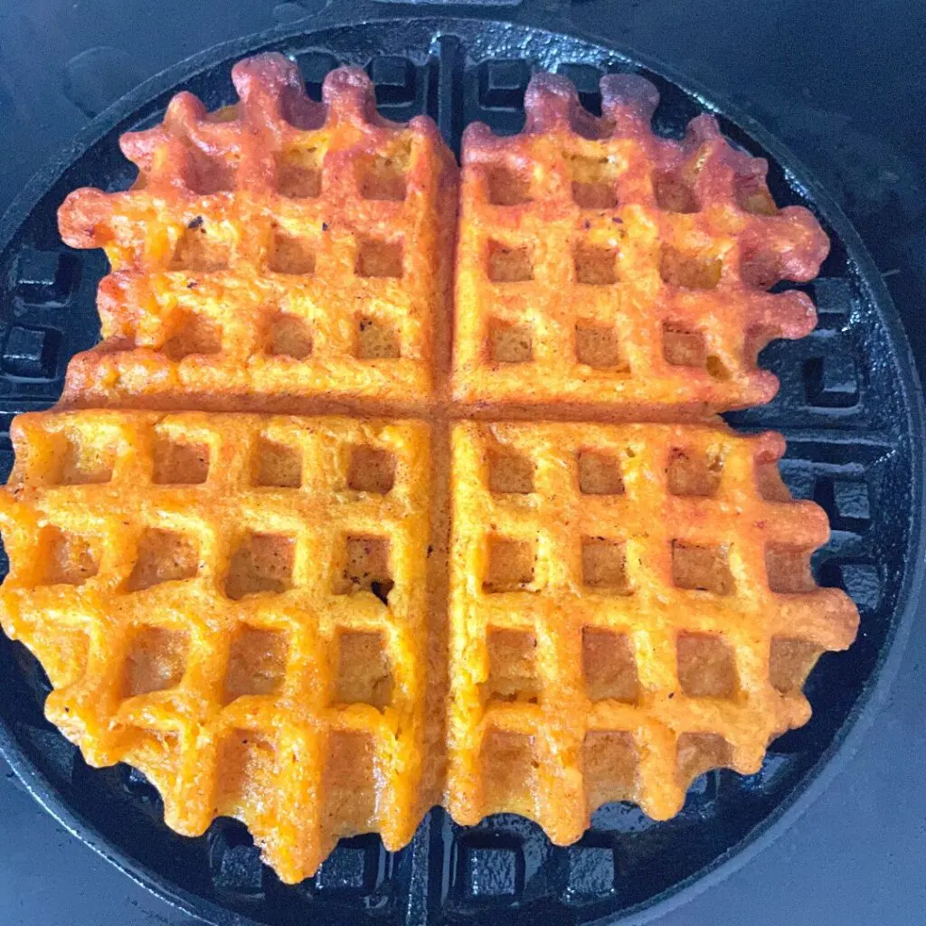 Whole wheat pumpkin waffle on a cast iron pan.