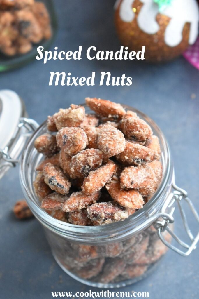 This 3 ingredient easy peasy Spiced Candied mixed Nuts are an addictive munching snack as well as a perfect edible homemade gift idea. Spiced Almonds are presented in a glass jar with some Christmas decoration seen in the side