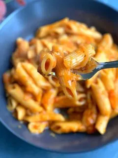 Vegan Butternut Squash Pasta is creamy and rich, one-pot cheese-free and dairy-free pasta made in an instant pot or open pot. Close up look of the pasta picked up on a fork.
