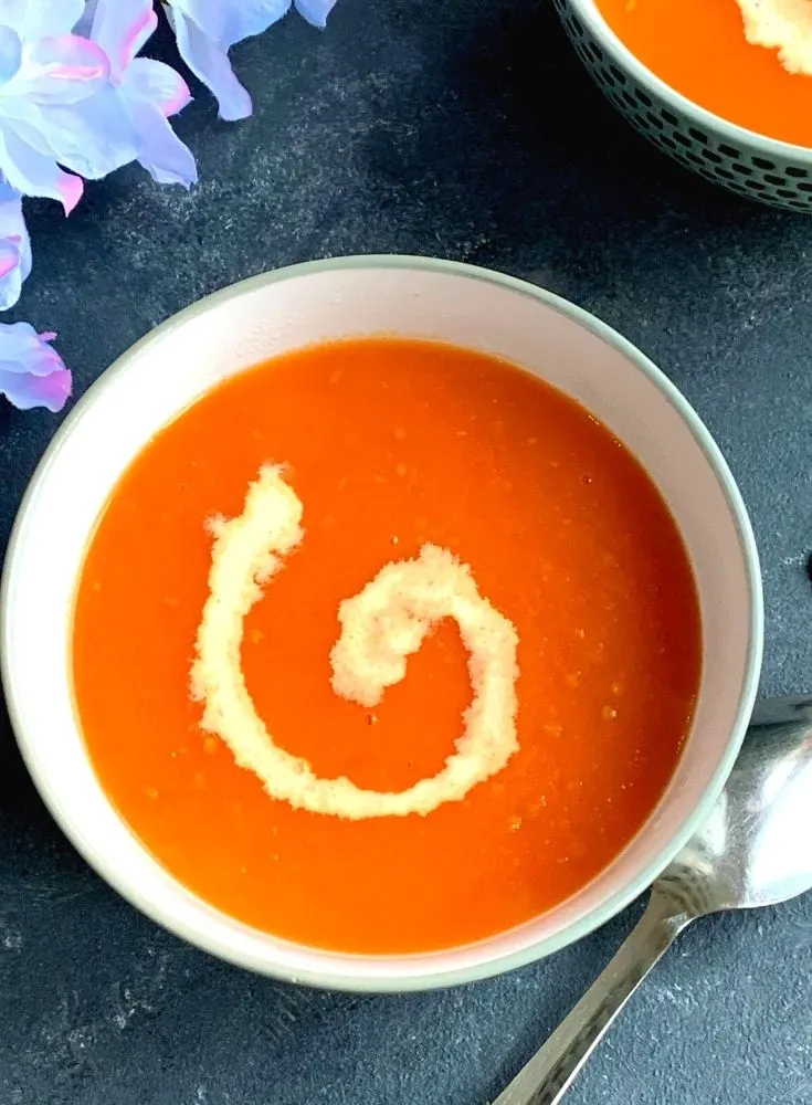 Close up look of soup served in a bowl with cream garnish