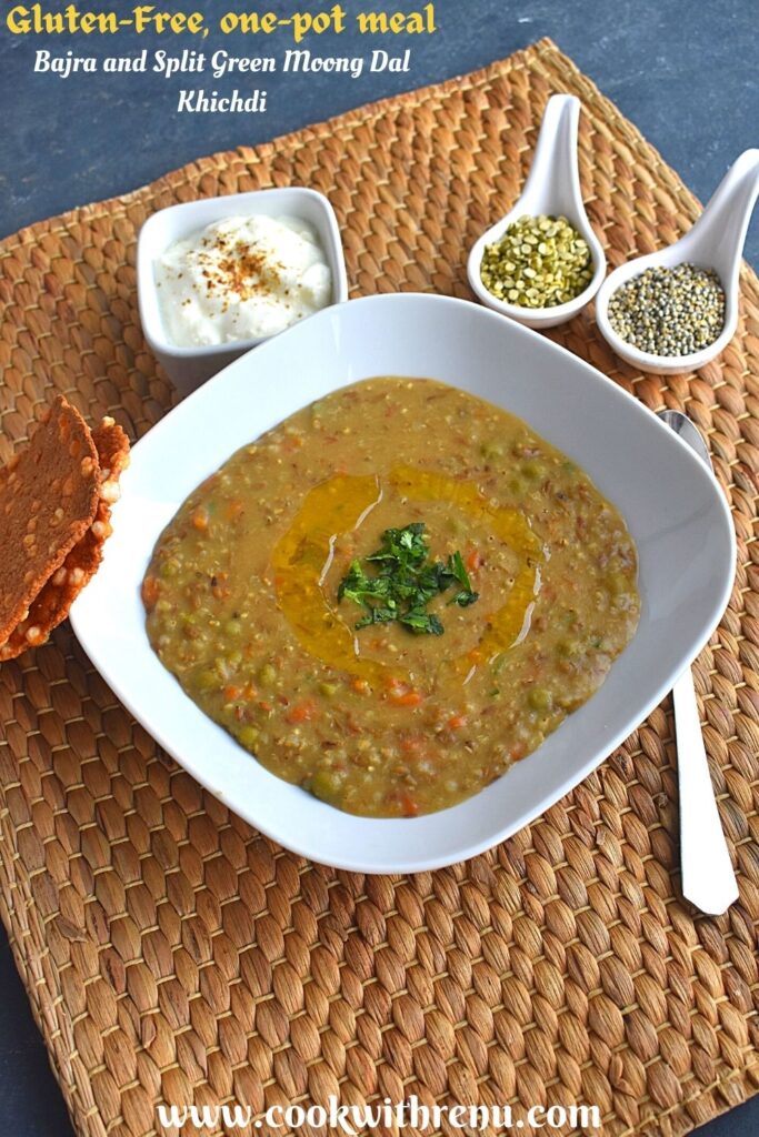 Bajra and Green Dal Khichdi served in a white rectangular bowl, with ghee drizzled on top and some coriander sprinkled. Seen in background is dal and bajra, along with dahi and sabudana (Sago seeds) papad