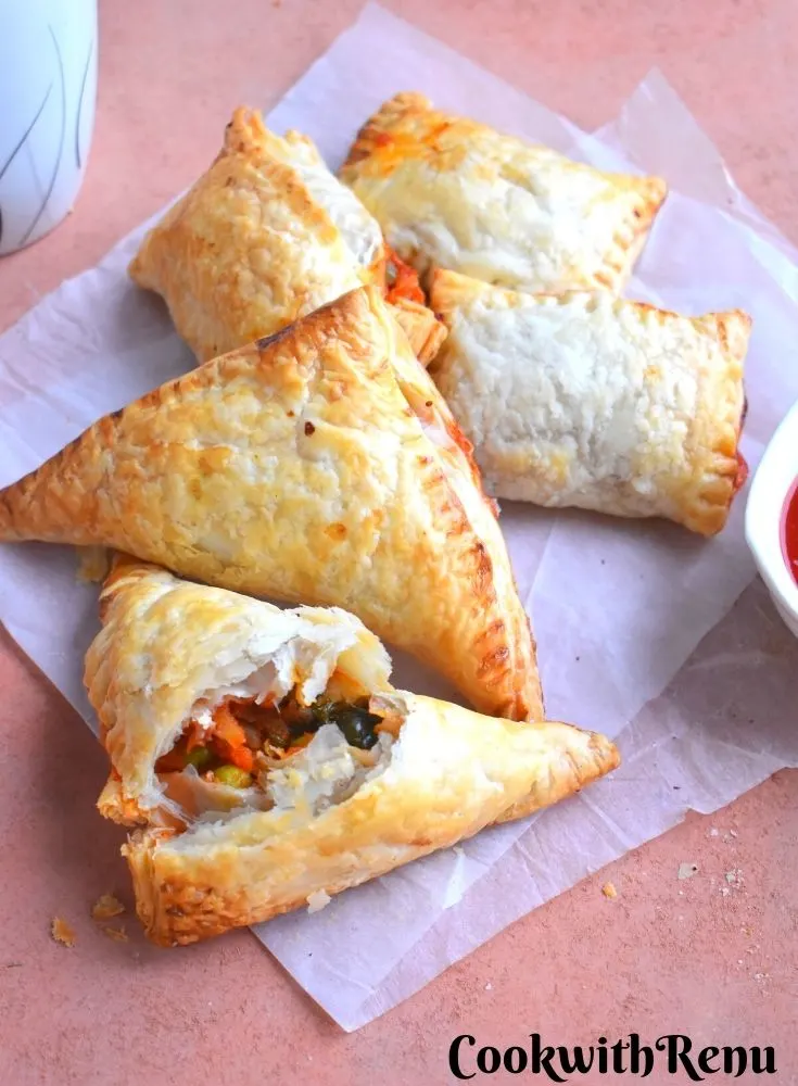 Few Veg Puff pastry seen with Tomato ketchup.