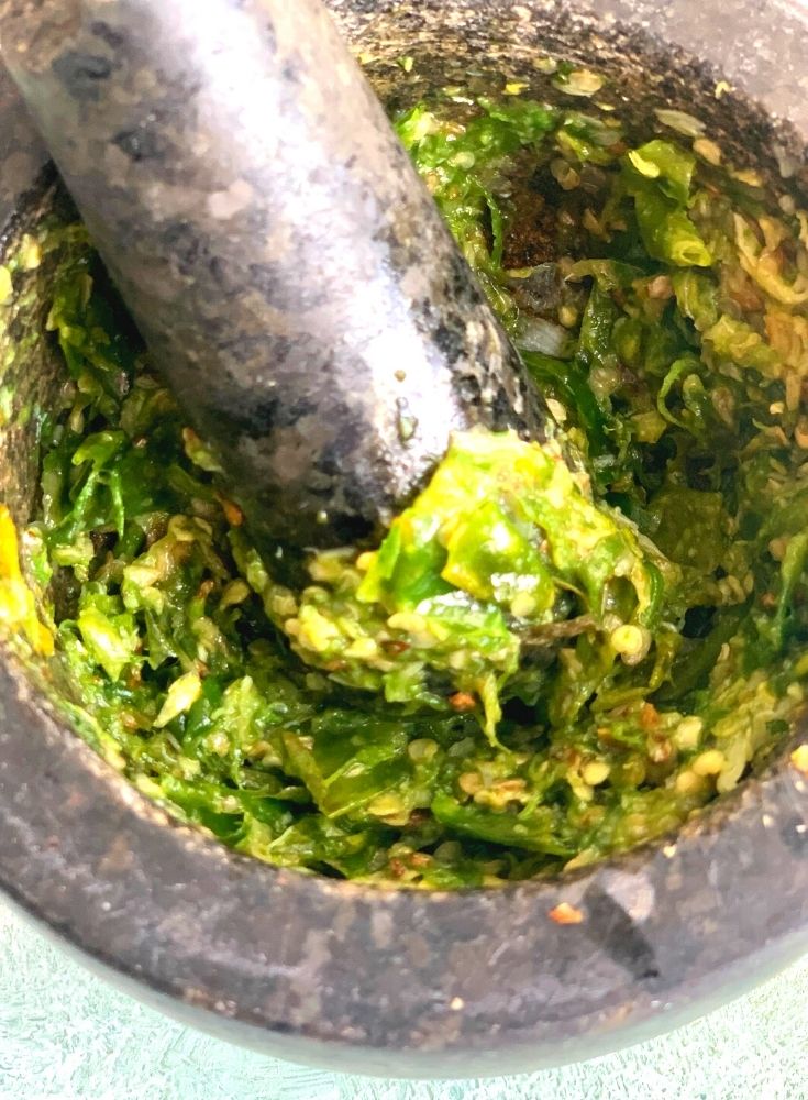 Chutney being grounded in a mortar and a pestle