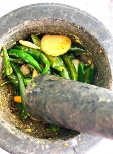 Chutney being grounded in a mortar and a pestle