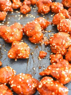 Close up look of Baked Spicy and Sweet Cauliflower Wings seen on a black baking tray