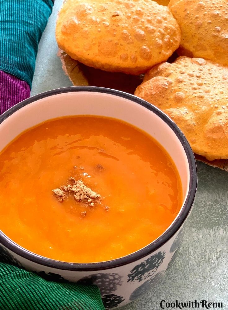A big bowl of Aam ras with some puris on the side