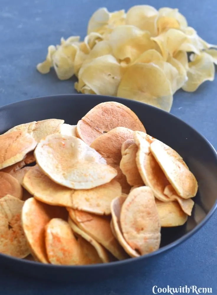 Fried Sun-Dried Potato Chips served in a blue bowl, with uncooked potato chips seen in background