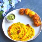 Dhuska pancake and appe served in a white dish with coconut chutney