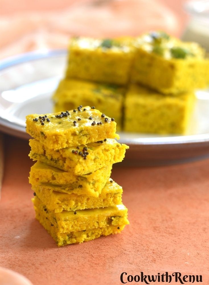Foxtail millet dhokla stacked up and presented , seen in the background is some more dhokla served on a plate