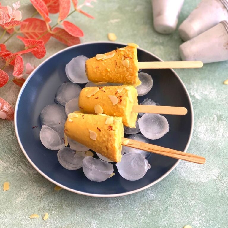 3 Kulfi kept on Ice cubes. Along side 3 more kulfi moulds seen