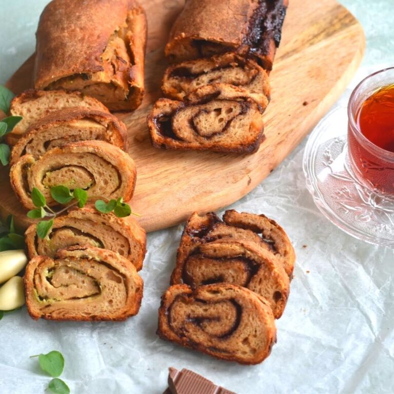 Swirl Sourdough Bread cut into slices and laid on a food board. Along side is a cup of tea
