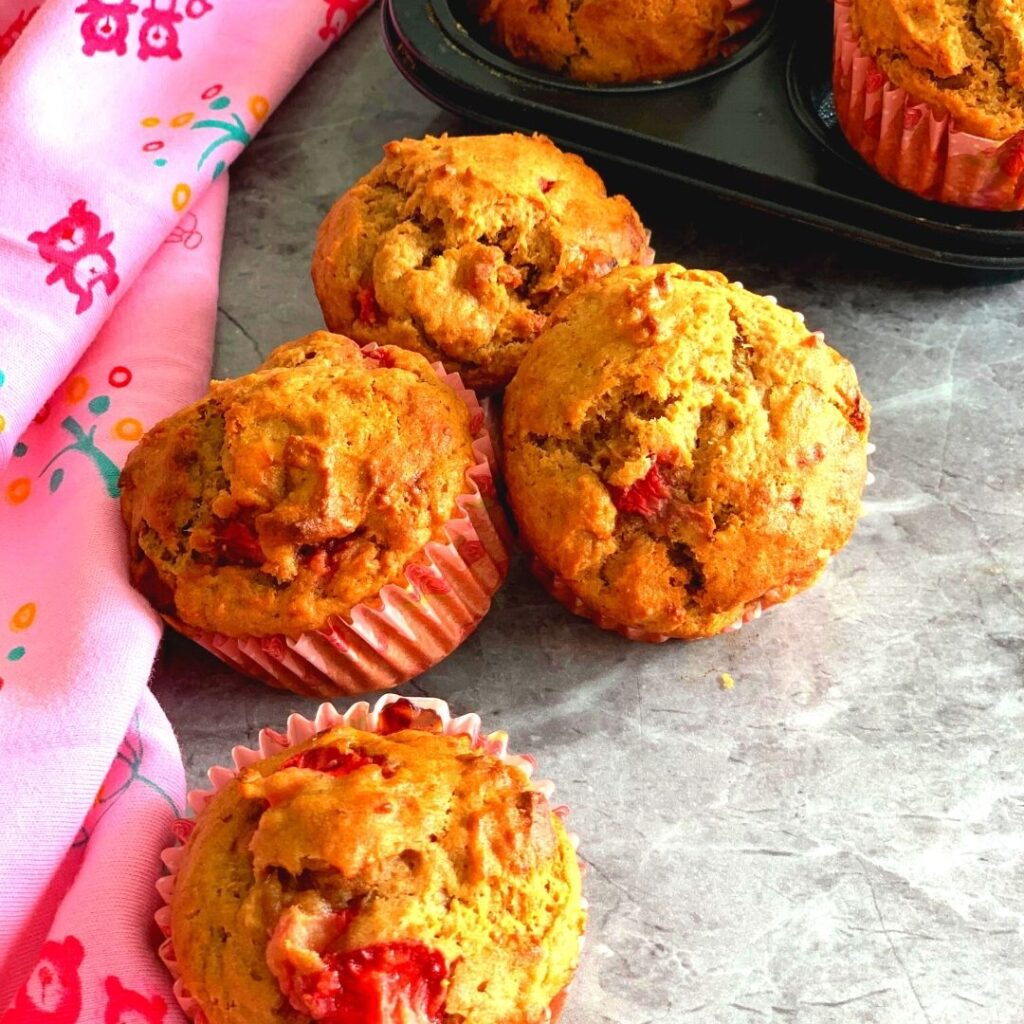 Eggless Strawberry Muffins seen on a grey table with a stole beside it