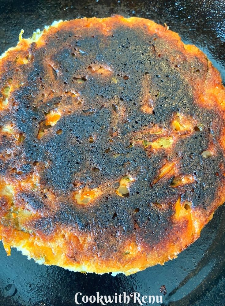 The bottom side of Pitha being cooked