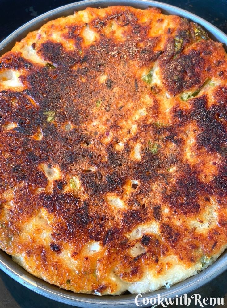 The bottom side of Pitha being cooked