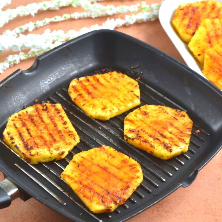 Peri Peri Grilled Pineapple on a grilled pan and seen in the background are more pineapple slices